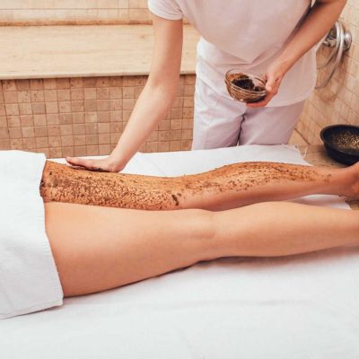 masseur-apply-a-mud-scrub-to-a-woman-s-legs-the-peeling-procedure-for-a-woman-will-make-her-legs